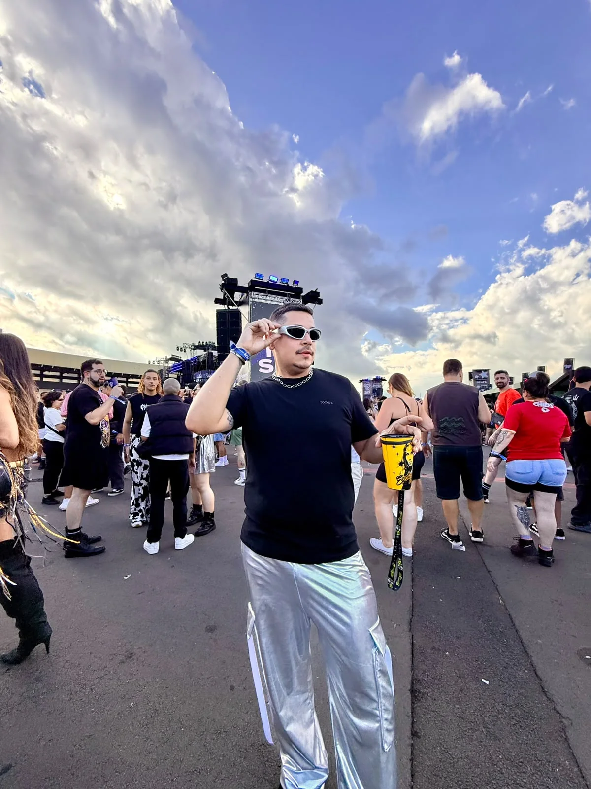 Lamins em evento, usando óculos claros e calça prateada